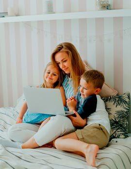 Mujer y niños sentados con ordenador portátil