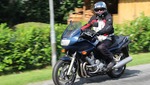 Un motorista bien uniformado y con su casco está dando un paseo en moto