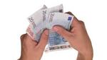Dos manos sujetan varios billetes