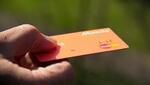 Un hombre sostiene una tarjeta de crédito en el mano