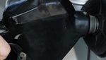 Una mano sujeta una manguera de carburante para echar gasolina a un coche