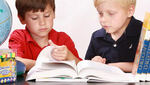 Dos niños están pasando páginas por un libro