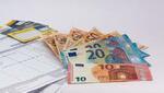 Varios billetes están sobre un contrato
